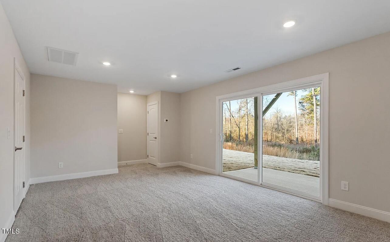6914 Woodland Stream Place Raleigh, NC 27616 - Photo 6 of 12 a view of an empty room with wooden floor and a window