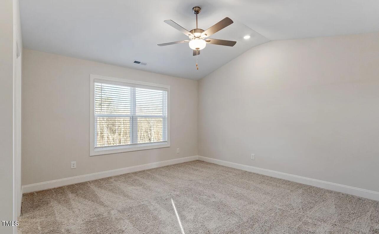 6914 Woodland Stream Place Raleigh, NC 27616 - Photo 9 of 12 an empty room with chandelier fan and windows