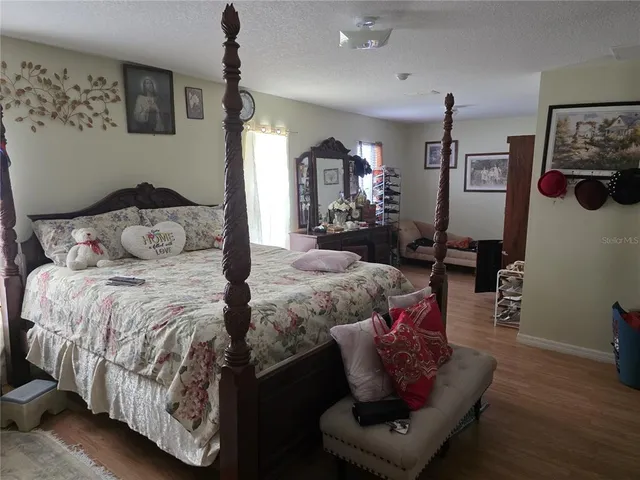 a bedroom with bed and wooden floor