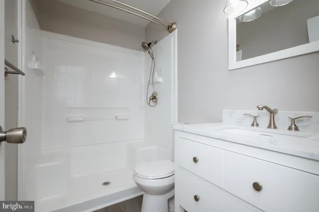 a bathroom with a granite countertop sink toilet and shower