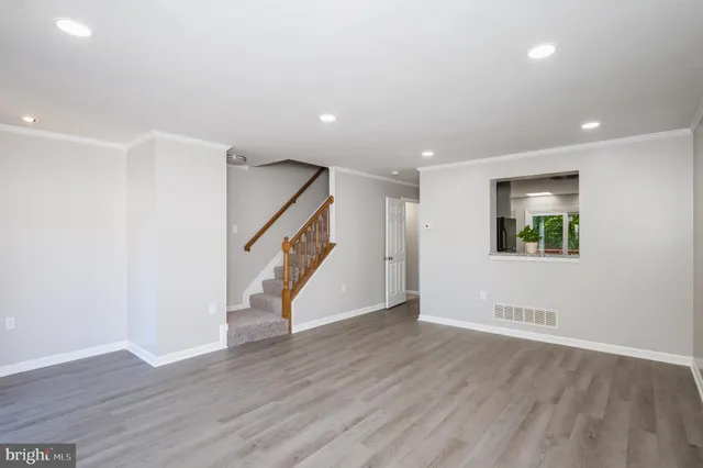 a view of an empty room with wooden floor