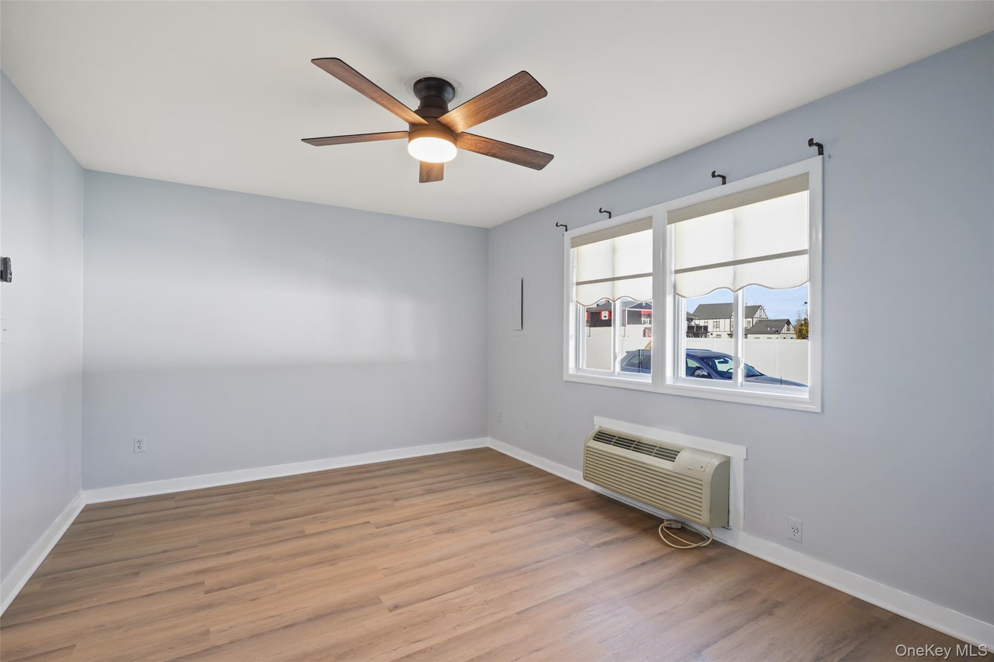 9 C Kings Court, Unit C Mohegan Lake, NY 10547 - Photo 12 of 31 an empty room with wooden floor fan and windows