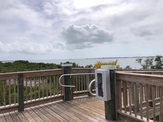 231 Pelican Lane Big Pine Key, FL 33043 - Photo 6 of 11 a view of roof deck with two chairs and wooden fence