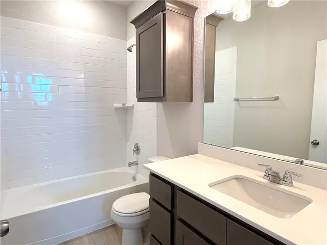 a bathroom with a sink a toilet and a mirror