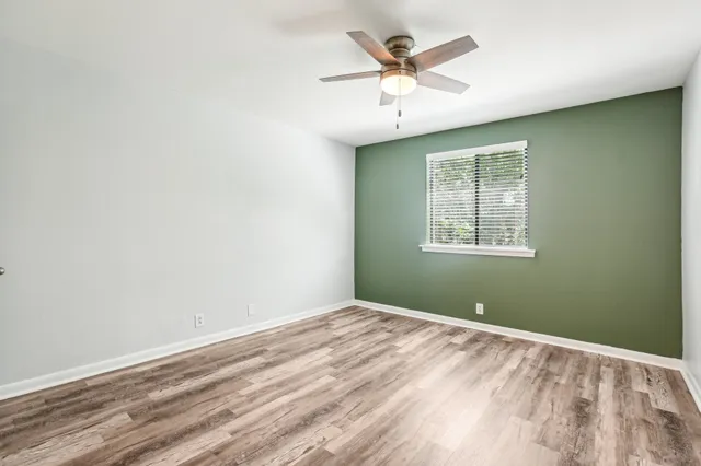 a view of a livingroom with wooden floor and a ceiling fan