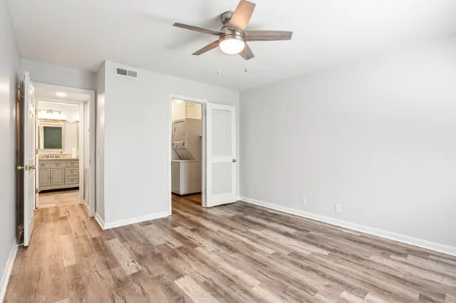 a view of a room with wooden floor and a ceiling fan