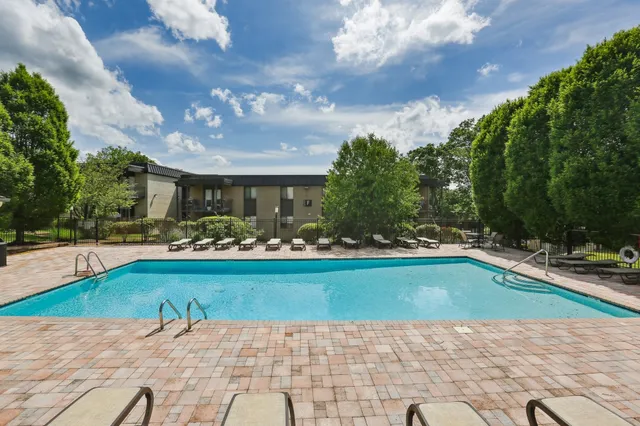 a patio with a table and chairs and potted plants