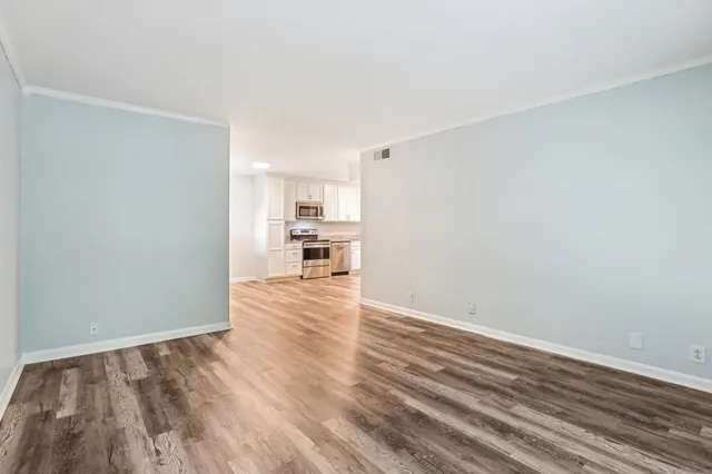 a view of a kitchen with wooden floor and a sink