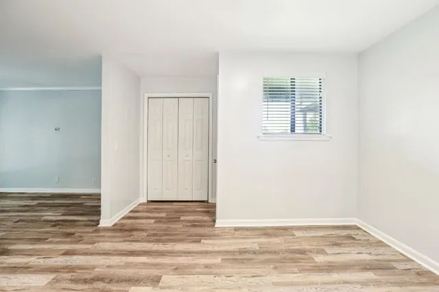 a view of an empty room with wooden floor