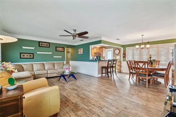 a dining room with furniture a chandelier and wooden floor
