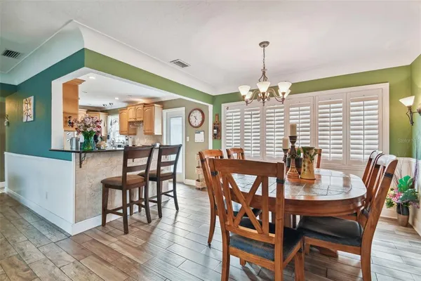 a kitchen with stainless steel appliances kitchen island granite countertop a stove top oven a sink a dining table and chairs
