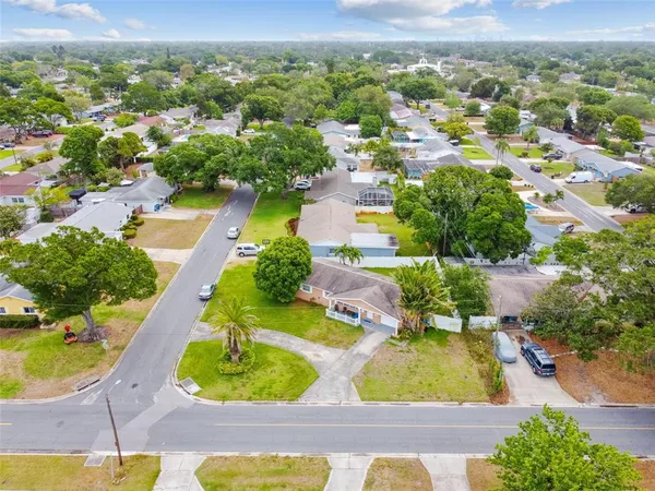 an aerial view of residential houses with outdoor space and parking