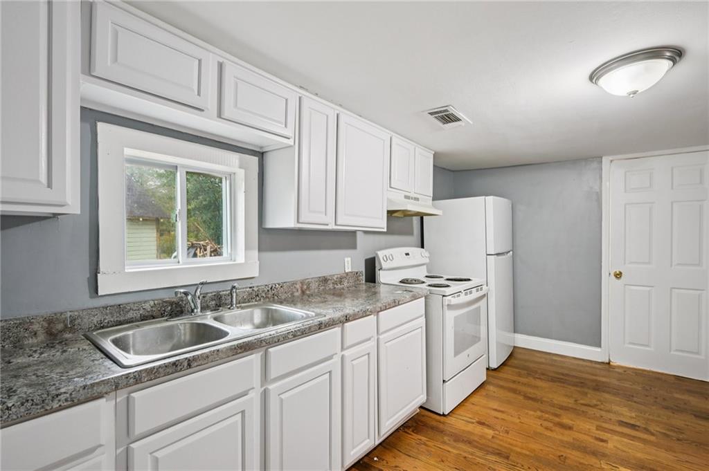5160 Avery Street Southwest Covington, GA 30014 - Photo 11 of 23 a kitchen with stainless steel appliances granite countertop a sink stove and refrigerator