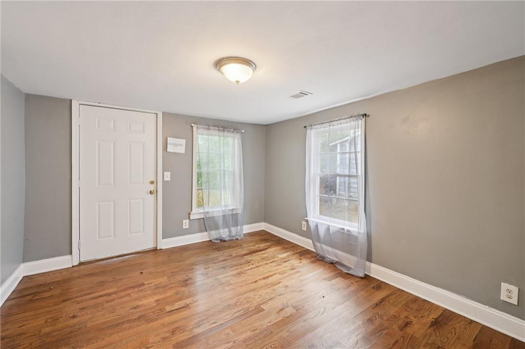 5160 Avery Street Southwest Covington, GA 30014 - Photo 18 of 23 a view of an empty room with wooden floor and a window