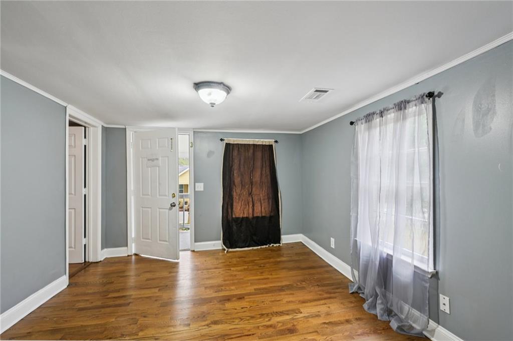5160 Avery Street Southwest Covington, GA 30014 - Photo 5 of 23 a view of an empty room with wooden floor and a window