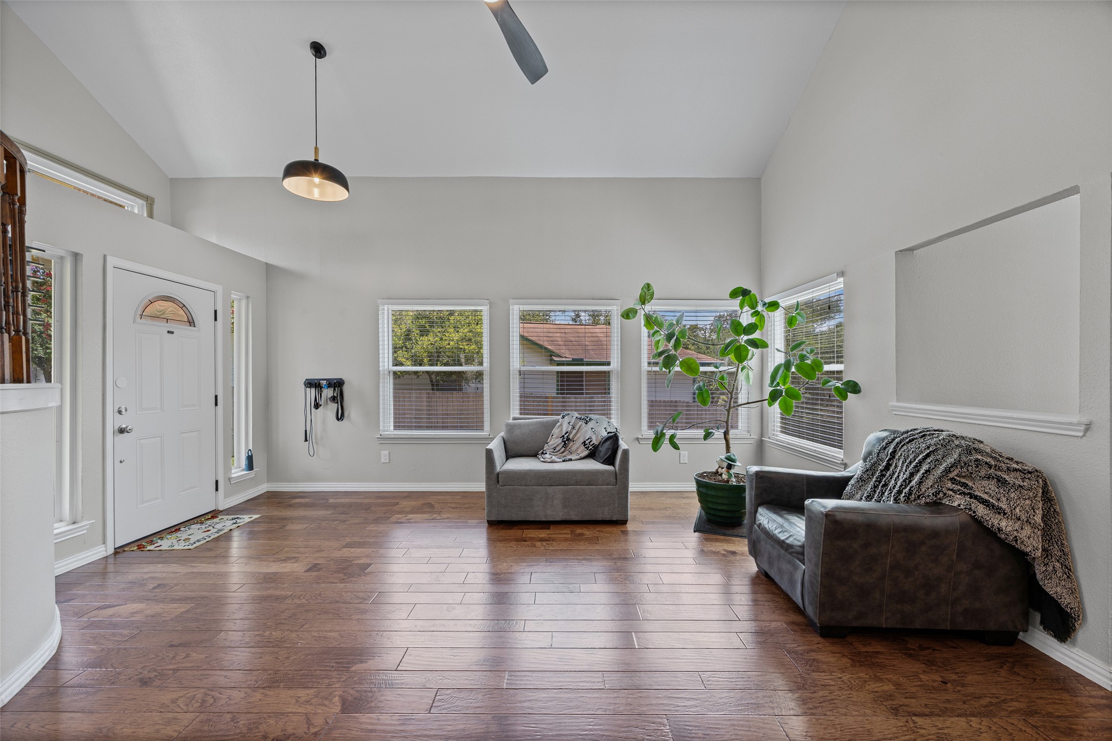 3011 Wadsworth Way Austin, TX 78748 - Photo 7 of 35 Natural light floods this living space, featuring high ceilings and beautiful hardwood flooring.
