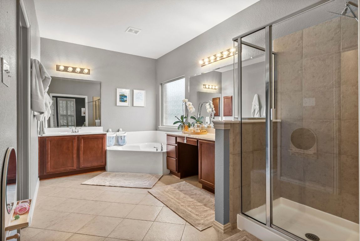 1912 Wildfire Leander, TX 78641 - Photo 17 of 40 a bathroom with a tub a sink shower and mirror