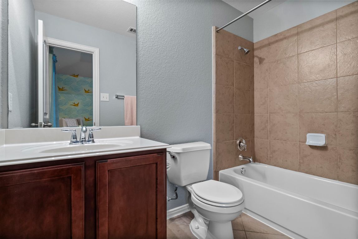 1912 Wildfire Leander, TX 78641 - Photo 25 of 40 a bathroom with a granite countertop toilet sink and mirror