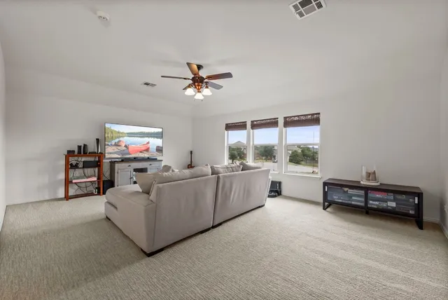 a living room with furniture and a ceiling fan