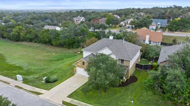 an aerial view of residential house with outdoor space and trees all around