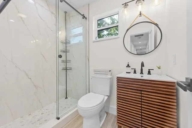 a bathroom with a sink a toilet and a mirror