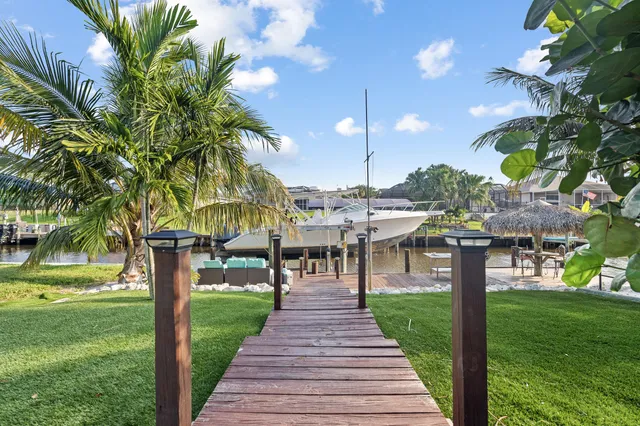 a front view of a house with a yard and potted plants