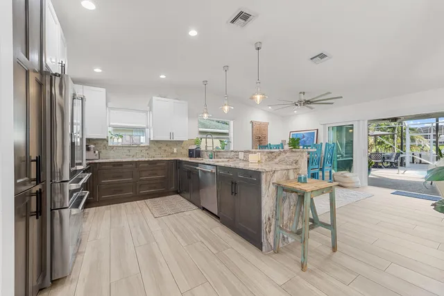 a kitchen with a sink a counter top space stainless steel appliances and cabinets