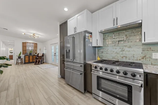 a kitchen with wooden floors and stainless steel appliances