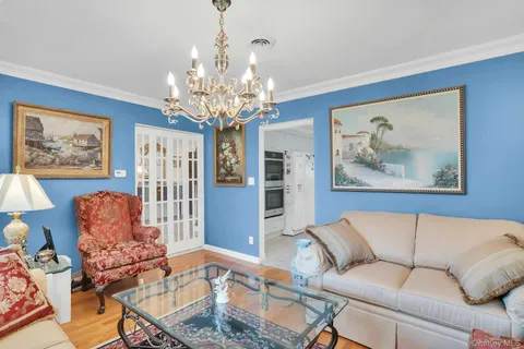 a view of a dining room with furniture a chandelier and wooden floor