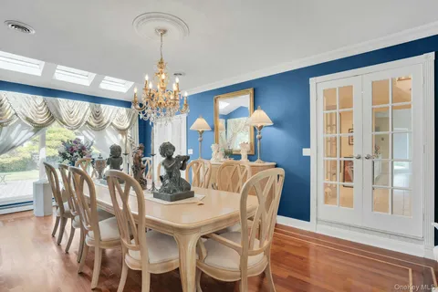 a view of a dining room with furniture a chandelier and wooden floor