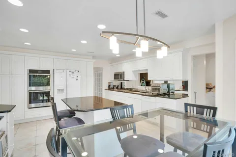 a kitchen with stainless steel appliances granite countertop a sink and a refrigerator