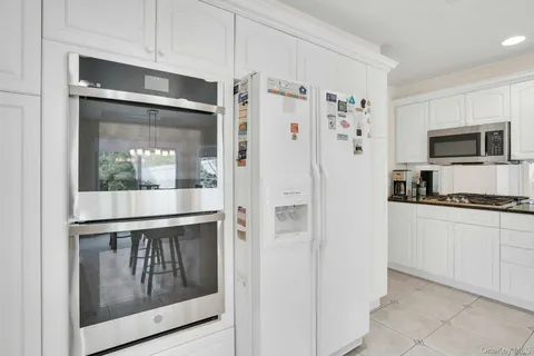 a kitchen with stainless steel appliances granite countertop a kitchen island a stove a sink a refrigerator a microwave and cabinets