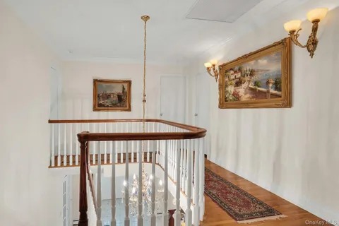 a bedroom with a bed a mirror on dresser and a flat screen tv