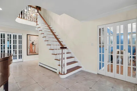 a living room with furniture a chandelier and a dining table