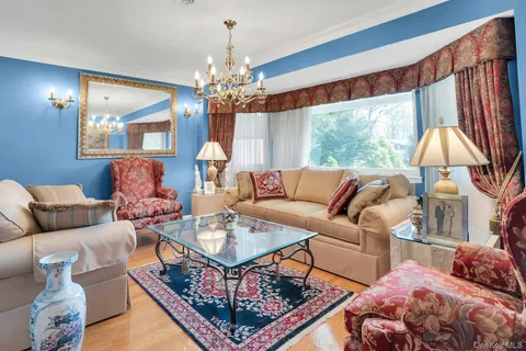 a living room with furniture a chandelier and a large window