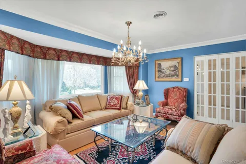 a living room with furniture a dining table and a chandelier