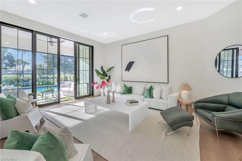 981 Tierra Lago Way Naples, FL 34119 - Photo 18 of 49 a living room with furniture and a floor to ceiling window