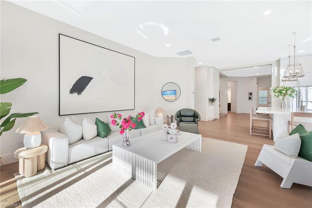 981 Tierra Lago Way Naples, FL 34119 - Photo 21 of 49 a living room with furniture and a large mirror with a potted plant