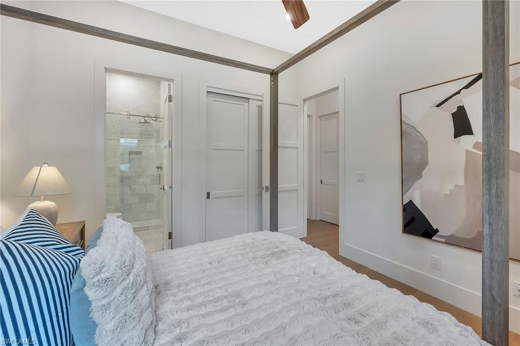 981 Tierra Lago Way Naples, FL 34119 - Photo 32 of 49 a bedroom with a bed and a large mirror