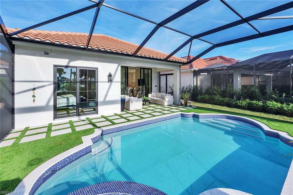 981 Tierra Lago Way Naples, FL 34119 - Photo 39 of 49 a swimming pool with patio outdoor seating and yard