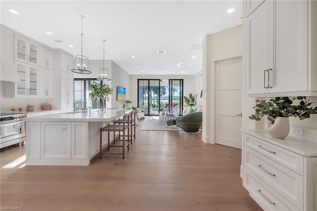 981 Tierra Lago Way Naples, FL 34119 - Photo 10 of 49 a open kitchen with white cabinets and stainless steel appliances