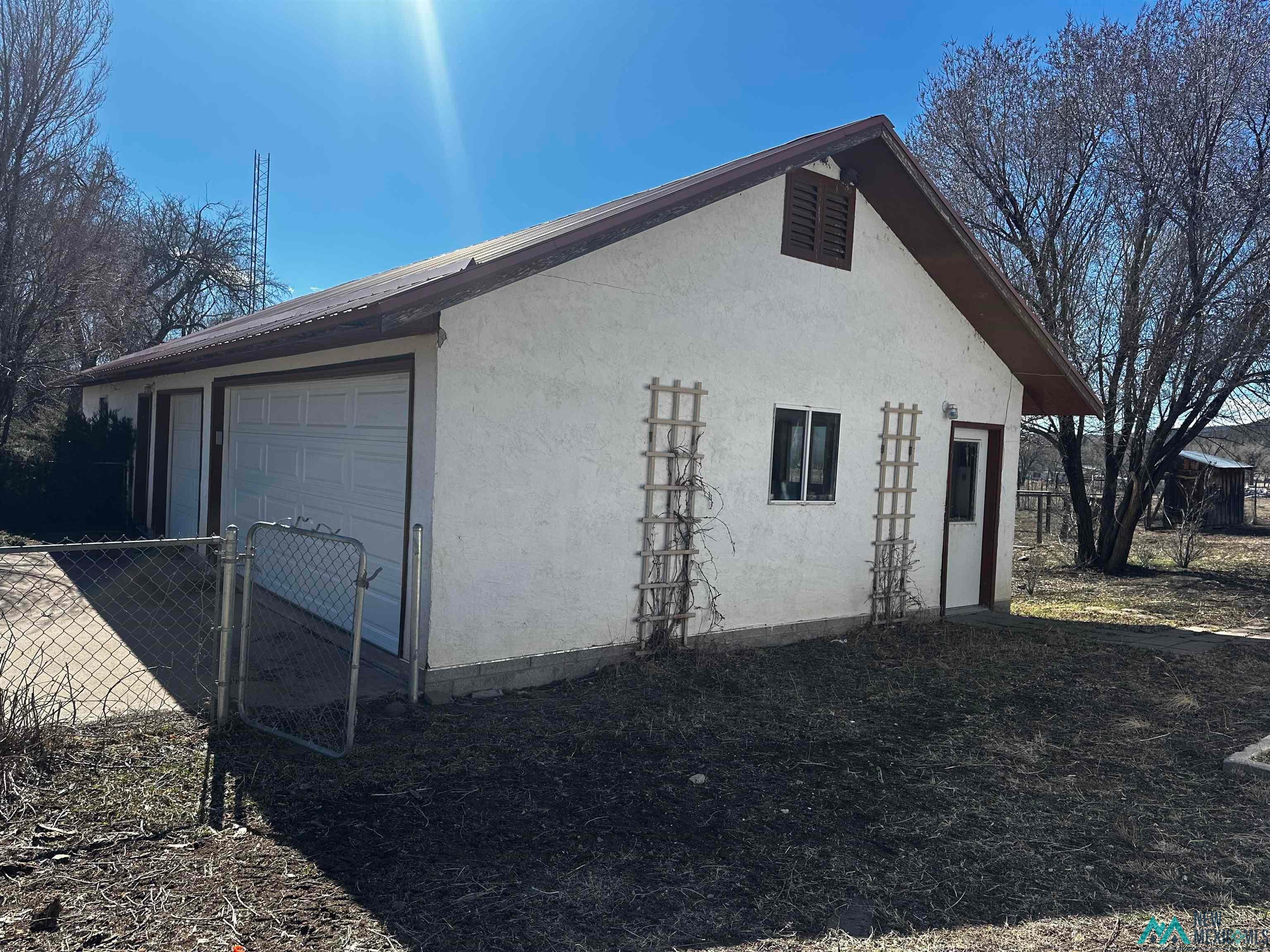 31 Bill Knight Gap Road Luna, NM 87824 - Photo 39 of 41 View of side of home featuring a garage, stucco siding, and an outbuilding
