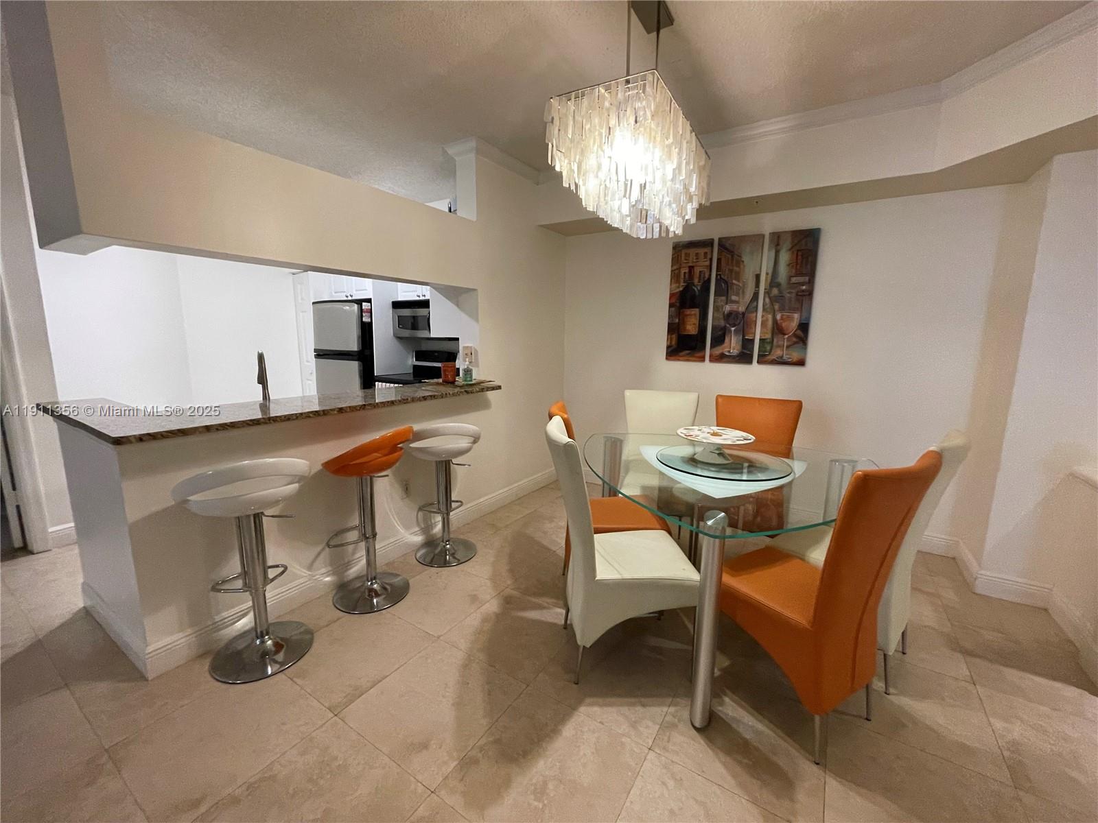 17100 North Bay Road, Unit 1118 Sunny Isles Beach, FL 33160 - Photo 22 of 34 a view of a dining room with furniture and chandelier