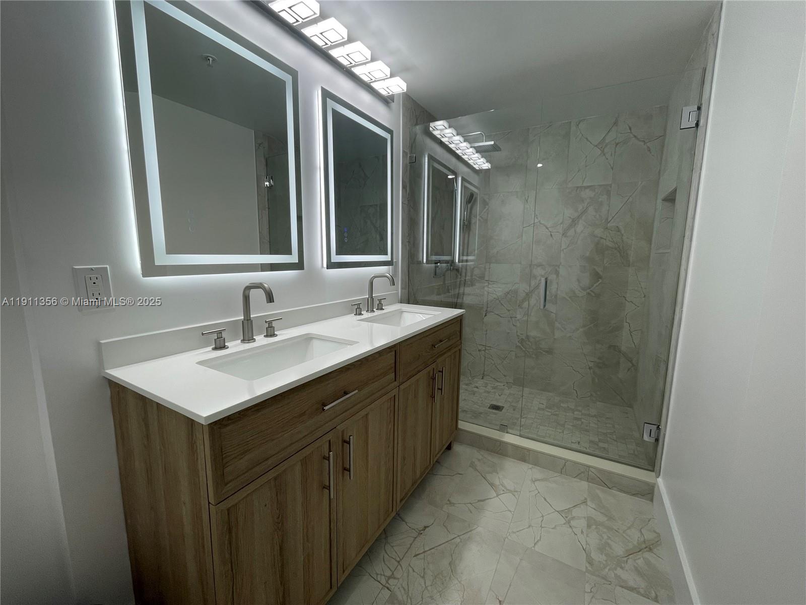 17100 North Bay Road, Unit 1118 Sunny Isles Beach, FL 33160 - Photo 26 of 34 a bathroom with a sink shower and a mirror