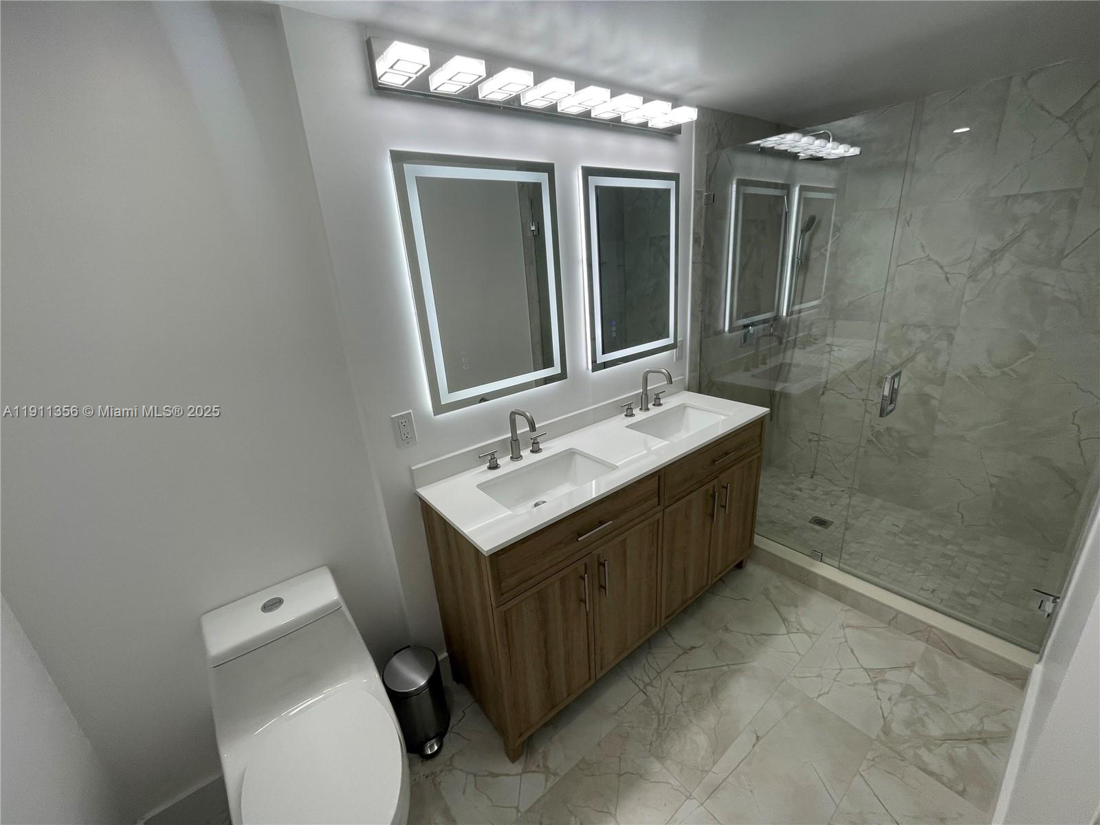 17100 North Bay Road, Unit 1118 Sunny Isles Beach, FL 33160 - Photo 27 of 34 a bathroom with a double vanity sink mirror and toilet