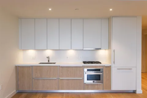 a kitchen with granite countertop white cabinets and stainless steel appliances