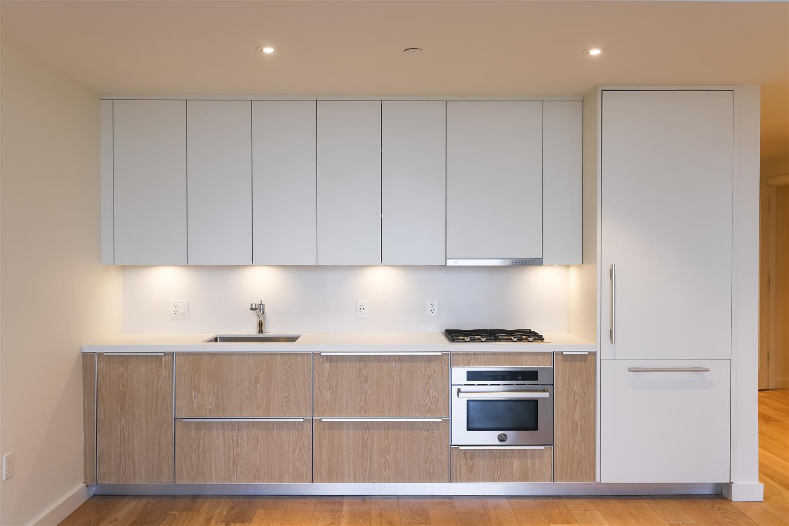 19 Dutch Street, Unit 50H Manhattan, NY 10038 - Photo 2 of 36 a kitchen with granite countertop white cabinets and stainless steel appliances