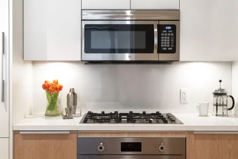 a stove top oven sitting inside of a kitchen