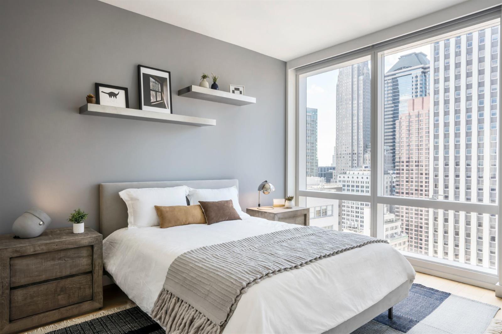 19 Dutch Street, Unit 50H Manhattan, NY 10038 - Photo 9 of 36 a bedroom with a bed and a large window