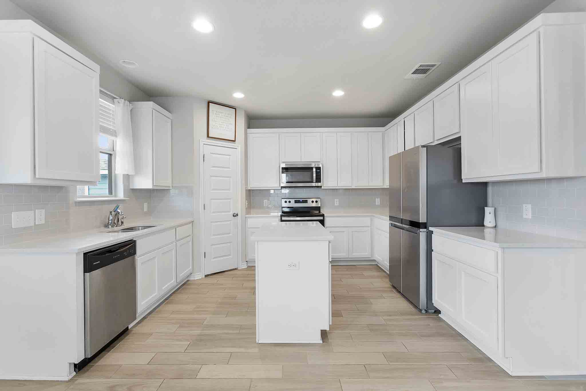 616 Barbary Coast Lane Jarrell, TX 76537 - Photo 8 of 37 a kitchen with white cabinets and stainless steel appliances